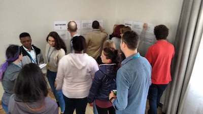 Workshop attendees scribbling on wall posters as an activity