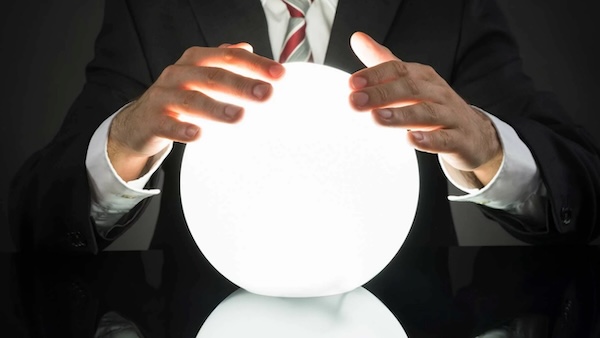 Awful stock photo of a businessman with a glowing, crystal ball-like, device